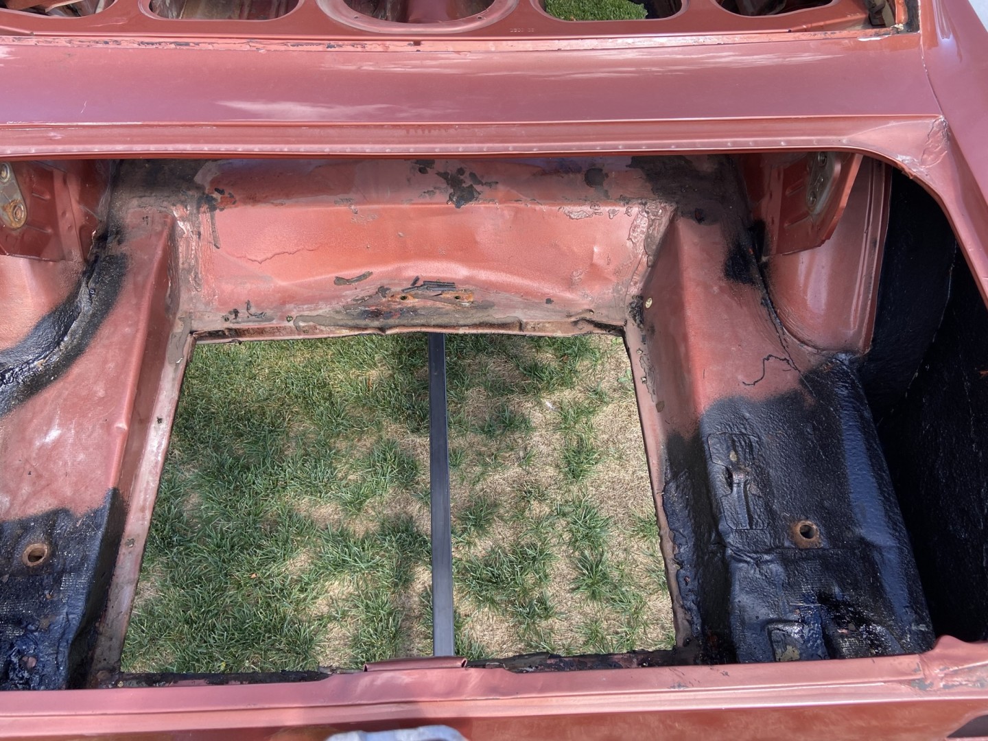 The wrinkled trunk with the not so square gas tank opening and rubber undercoating sprayed over all the other messed up metal and rust spots. 